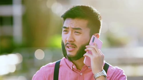 Asian Man Talking to the Mobile in the Street During Sunset