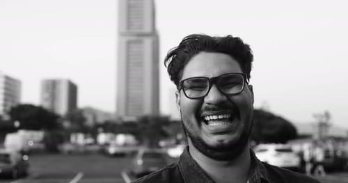 Smiling young latin man looks at camera in black and white New York City