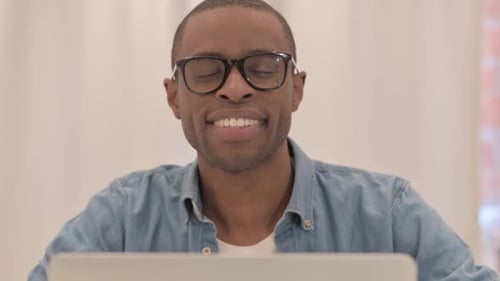 Man Smiling at Laptop, Close Up