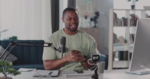 Man Recording a Podcast at Desk Indoors
