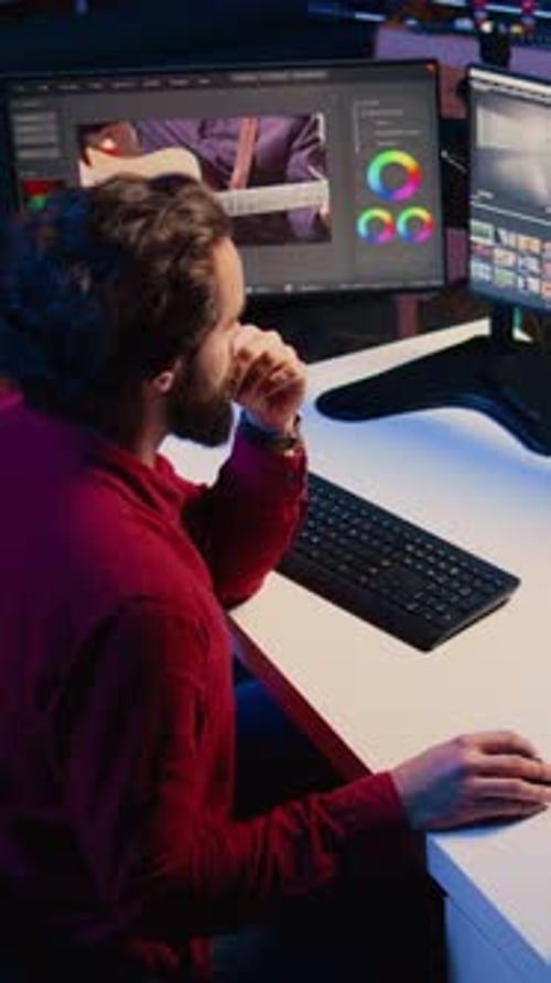 Young Adult Editing Video at Computer Workstation