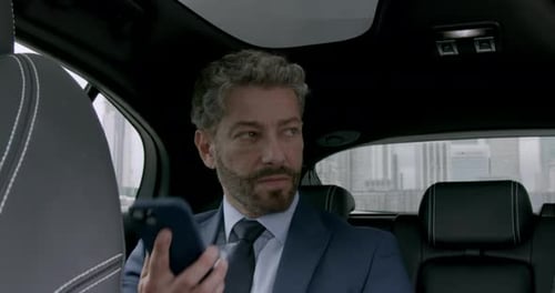 Executive Business person Sitting in Taxi using Phone
