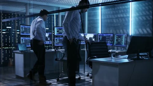 Zwei technische Ingenieure nehmen ihre Plätze im Mission Control Room ein. Der Überwachungsraum verfügt über mehrere Kommunikationsgeräte