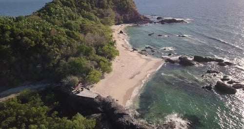 Aerial view of a magnificent landscape: an island with white beach, crystal clear sea, palm trees.