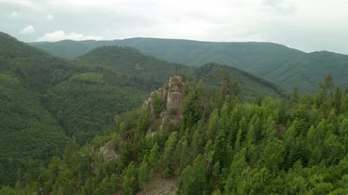 Aerial 4K drone footage circling around a top of a hill with a Christian cross near Osrblie, Central