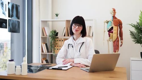 Confident Female Doctor at Office Desk Ready to Assist Patients