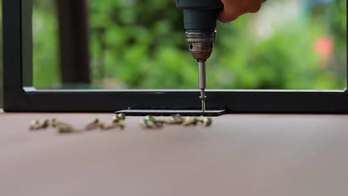 Electric Drill Driving Screw into Metal