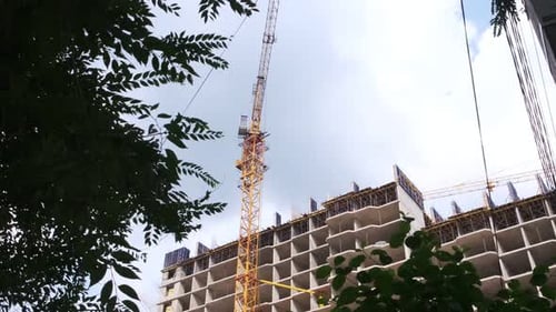 Unfinished building on a construction site. Self-erecting industrial crane near a building. Concrete