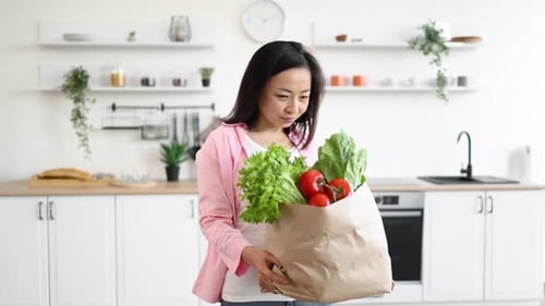 Woman with Groceries in Kitchen
