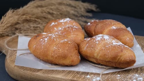 Powdered Sugar Rolls on Wooden Board
