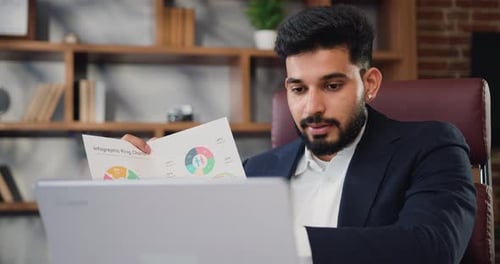 Young Adult Reviews Infographics in Office Workplace