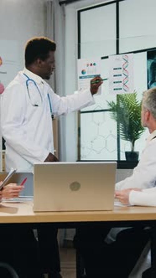 Doctor Presents Medical Data to Colleagues in Office