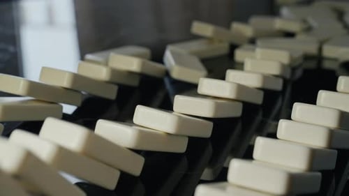 Fallende Dominosteine lösen eine kontinuierliche Kettenreaktion aus, Symbol für Ursache und Wirkung
