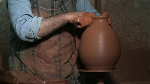 Potier professionnel fabriquant un vase en céramique au tour de potier.
