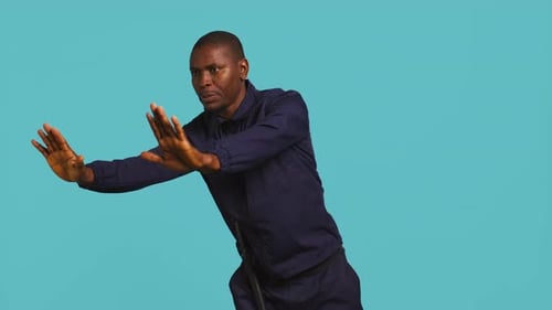 Man with Baton Pushes Against Light Blue Background