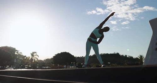 Fit African Woman Doing Sport Stretching Exercise in the City with Sunset