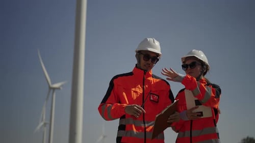 Engineers work at windmill farm.