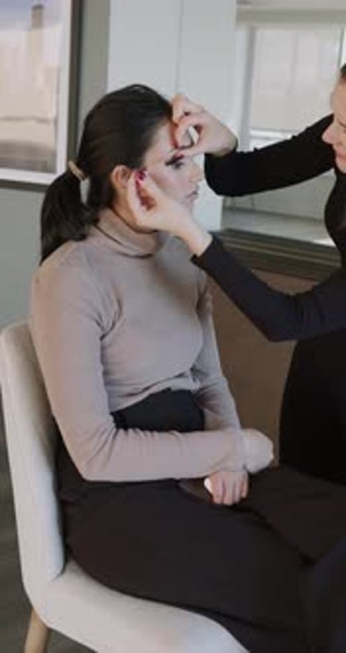 Visagist trägt Wimperntusche mit einem individuellen Pinsel auf die Wimpern des Kunden auf