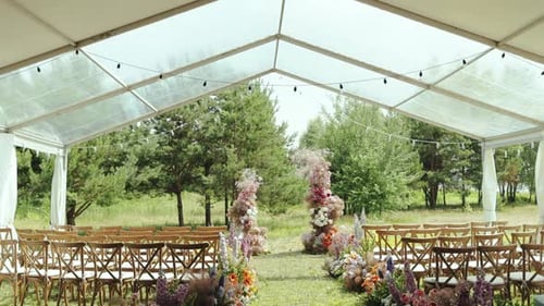 Outdoor Wedding Ceremony Under the Tent in Garden Among the Trees View of Beautiful and Tender