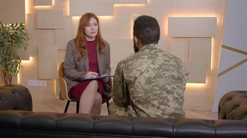 Rear View of Black Male Soldier with PTSD Counselling with Psychotherapist