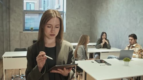 Young Student is Using Tablet to Study in College She Looks at the Camera She Stands in Classroom