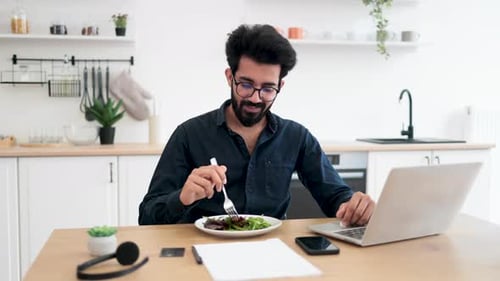 Employee Eating Salad During Lunch Break in Home Office