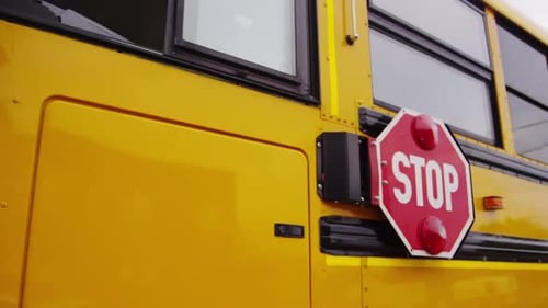 Kinder fahren mit dem Schulbus zum Unterricht - Steadicam vom Stoppschild zur Vorderseite des Busses