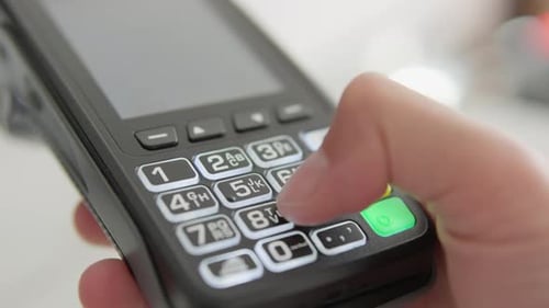 This Image Shows a Closeup of a Hand Using a Modern Touchscreen Smartphone with a Numeric Keypad