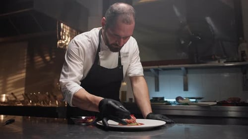 Chef Carefully Plates Gourmet Food in Restaurant Kitchen