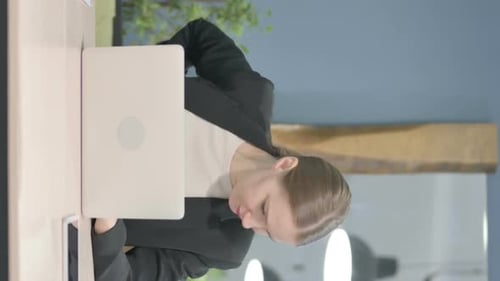 Woman Using Laptop at Desk in Modern Office