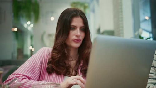 Young Woman Working on Laptop in a Cafe