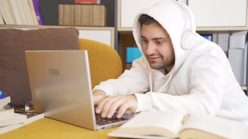 Young Adult Typing on Laptop at Home