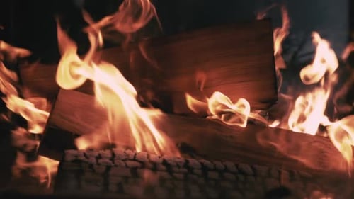 Burning Firewood in a Dark Fireplace, Close-up