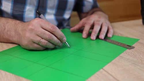 11Hands drawing cutting lines on colored cardboard, crafting template for paper model, DIY project p
