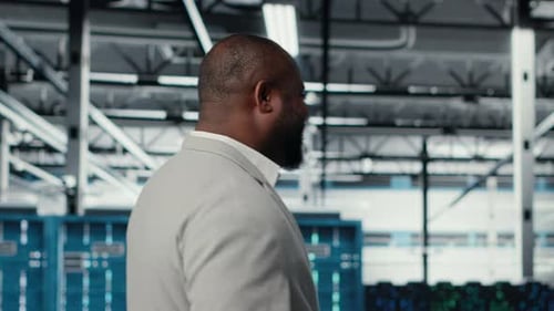 Happy Businessman Walking in Data Center Assessing Capacity Before Investing