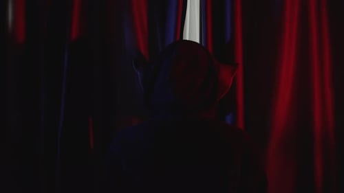Scary Man with Pig Mask Looking Behind Curtains in Red Room