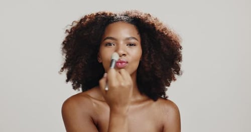 Face, woman and brush for makeup, studio or foundation for skin with cosmetics, artist or pout