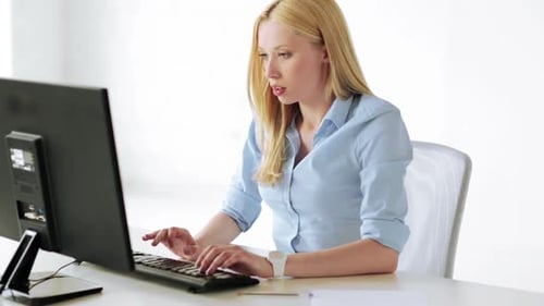 Tired business woman works late at computer in corporate office environment