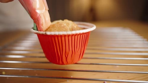 Rainbow-colored cream is squeezed in a circle onto the cupcake. Festive baking.