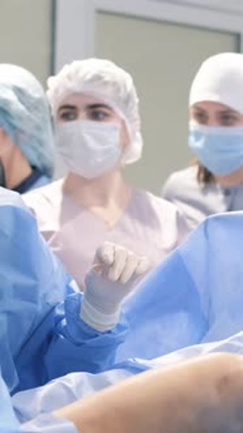 A Professional Team of Doctors During an Operation in a Modern Operating Room Vertical Video