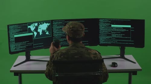 Man Soldier Drinking Coffee And Using Computer To Write Code With Multiple Screens In Green Screen