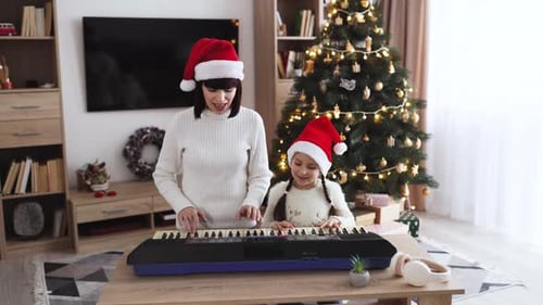 Mother and Daughter Play Keyboard at Christmas Time