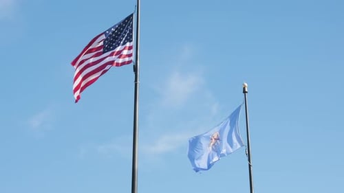 The American and Oklahoma flags flying next to each other, slow motion