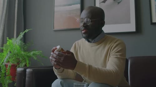 Man Reads Pill Bottle Label at Home