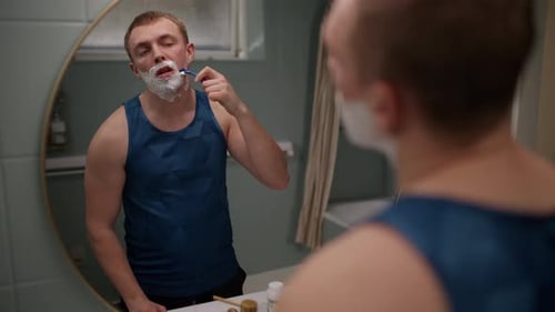 Homem raspando barba e bigode com uma navalha