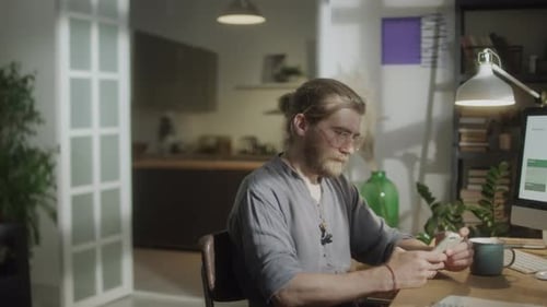 Young Adult Using Mobile Phone at Desk