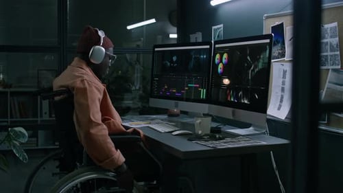 Person in Wheelchair Working at Computer at Night