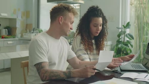 Young Couple Reviewing Financial Documents Together at Home