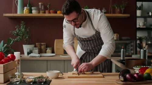 Male Chef Cutting Cooked Chicken Breast into Slices