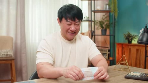 Asian Happy Man Counting Money Dollars Cash Pleased with Earned Income Celebrates Big Financial Gain